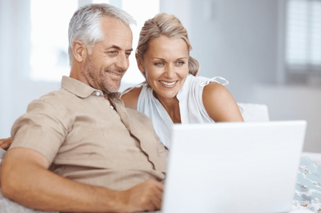 a husband and wife looking at the computer