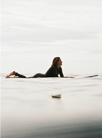 Surfer waiting in the water, illustrating patience and timing
