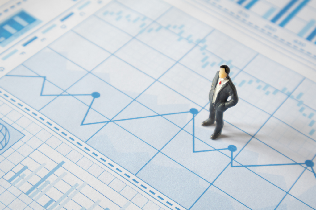 Small suited figure on a financial report chart, representing stock options in an acquisition.